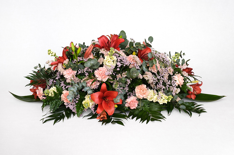 Centre amb lilium vermell, clavells rosa, conillet blanc, estatice rosa clar, cordelini, chico, leder i eucaliptus