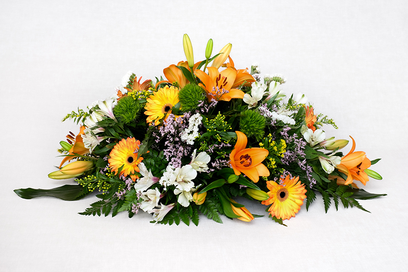 Centre amb lilium taronja, gerbera taronja, astromedia blanca, solidago, estatice rosa, barbatos verd, cordelini i leder