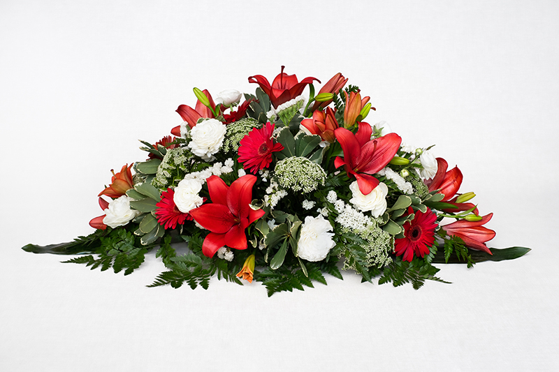 Centre amb lilium vermell, gerbera vermella, animajus, clavell blanc, estatice, cordelini i leder